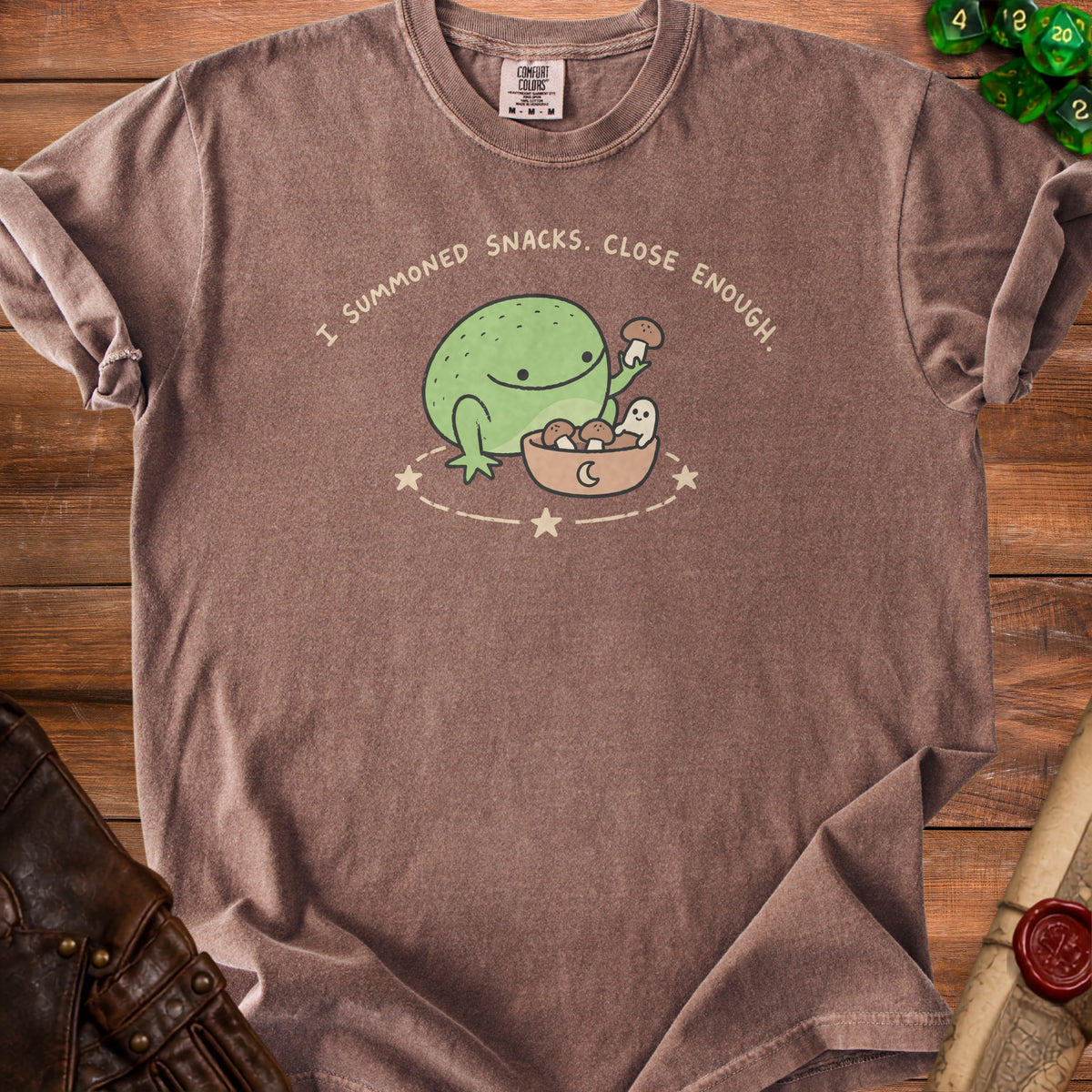 Brown t-shirt with a graphic of a frog and ghost saying "I summoned snacks. Close enough."