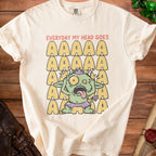 Cream t-shirt with green monster graphic and text "EVERYDAY MY HEAD GOES" and repeating "A"s.