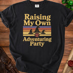 Black t-shirt with "Raising My Own Adventuring Party" text and wizard hats.