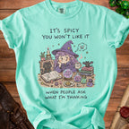 Aqua t-shirt with witch graphic and text "IT'S SPICY YOU WON'T LIKE IT WHEN PEOPLE ASK WHAT I'M THINKING."