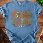 Blue t-shirt with "Potion Weather" text, potion bottle, pumpkin, and mushrooms.