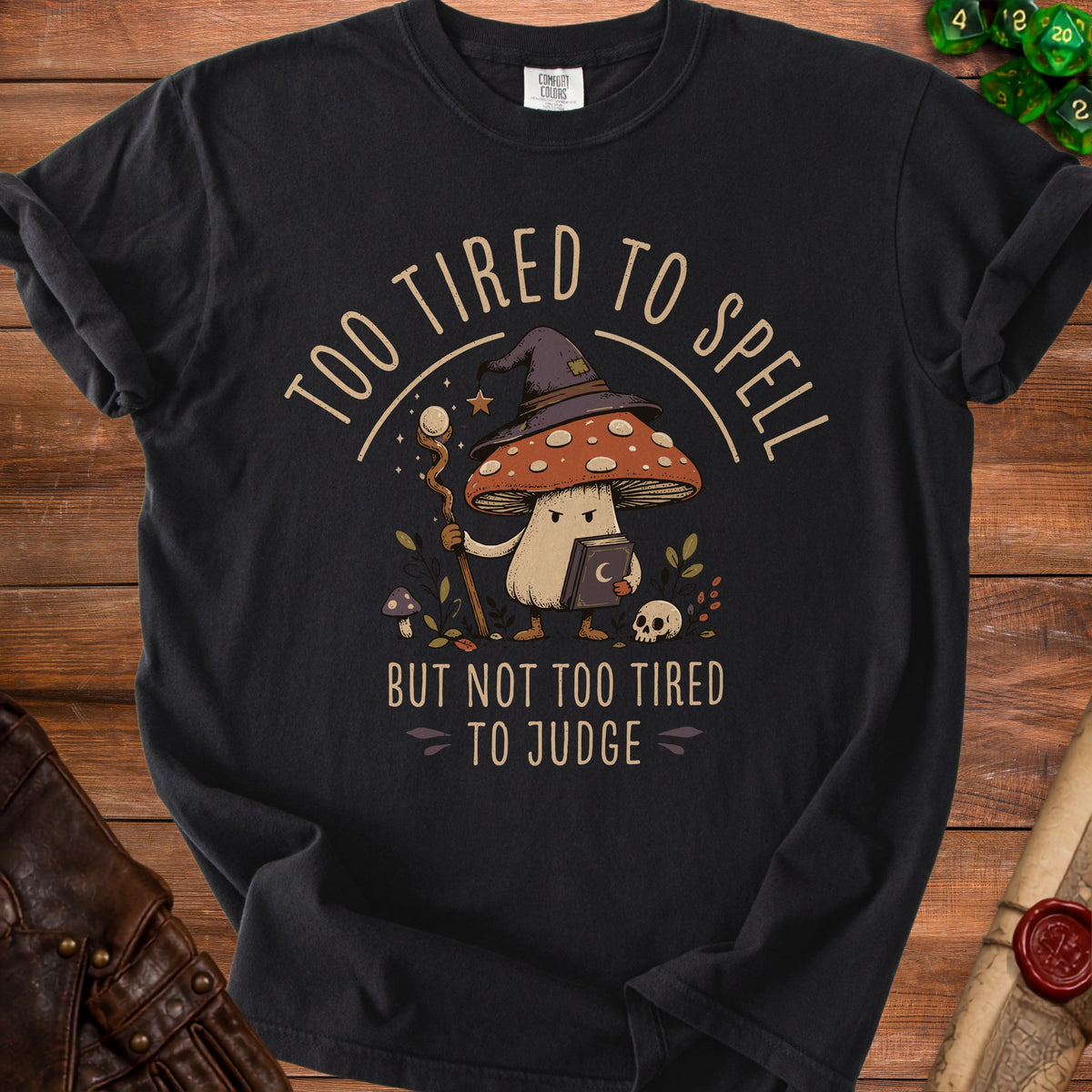 Black t-shirt with wizard mushroom graphic saying "Too tired to spell but not too tired to judge."