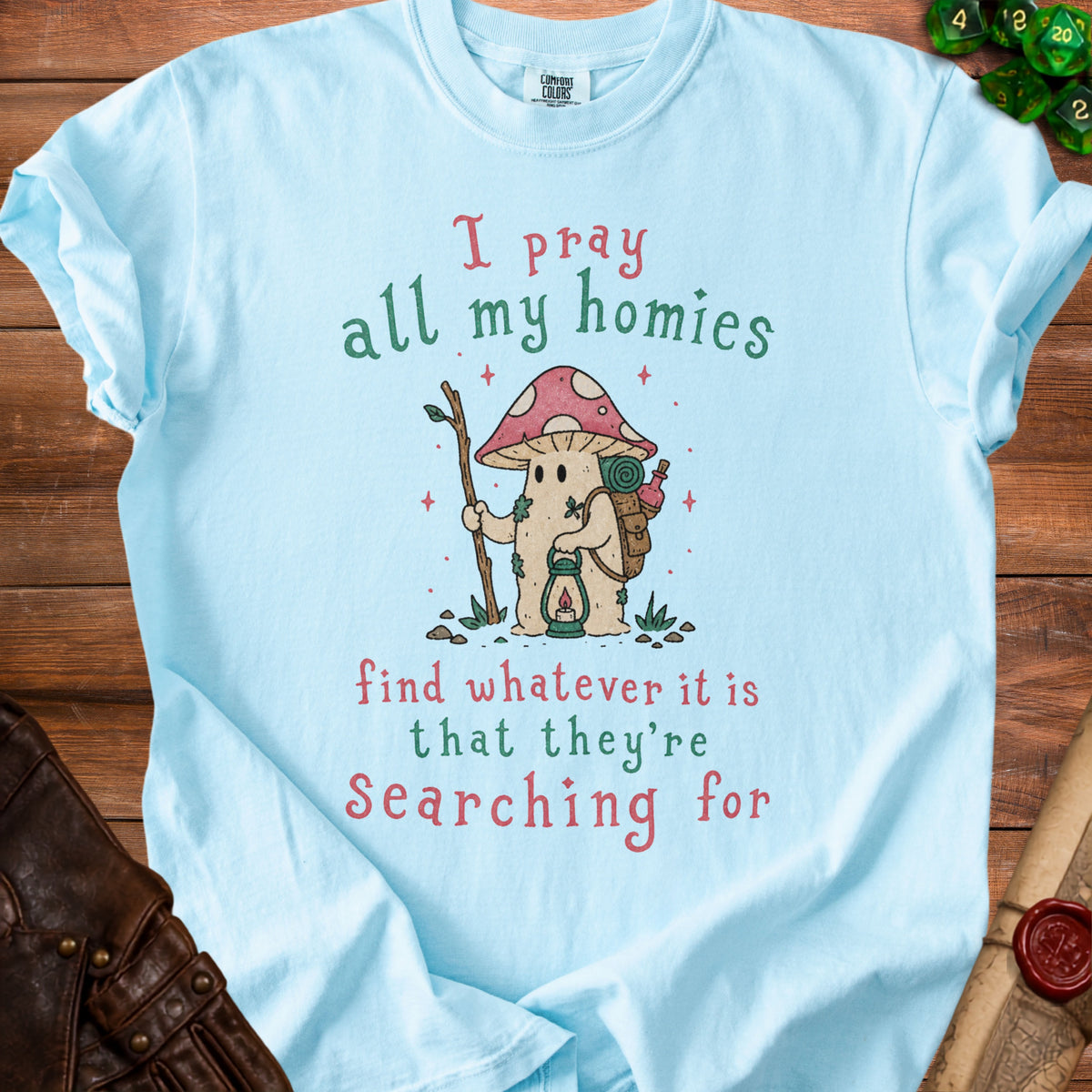 Light blue t-shirt with mushroom character and text: "I pray all my homies find whatever it is that they're Searching for."