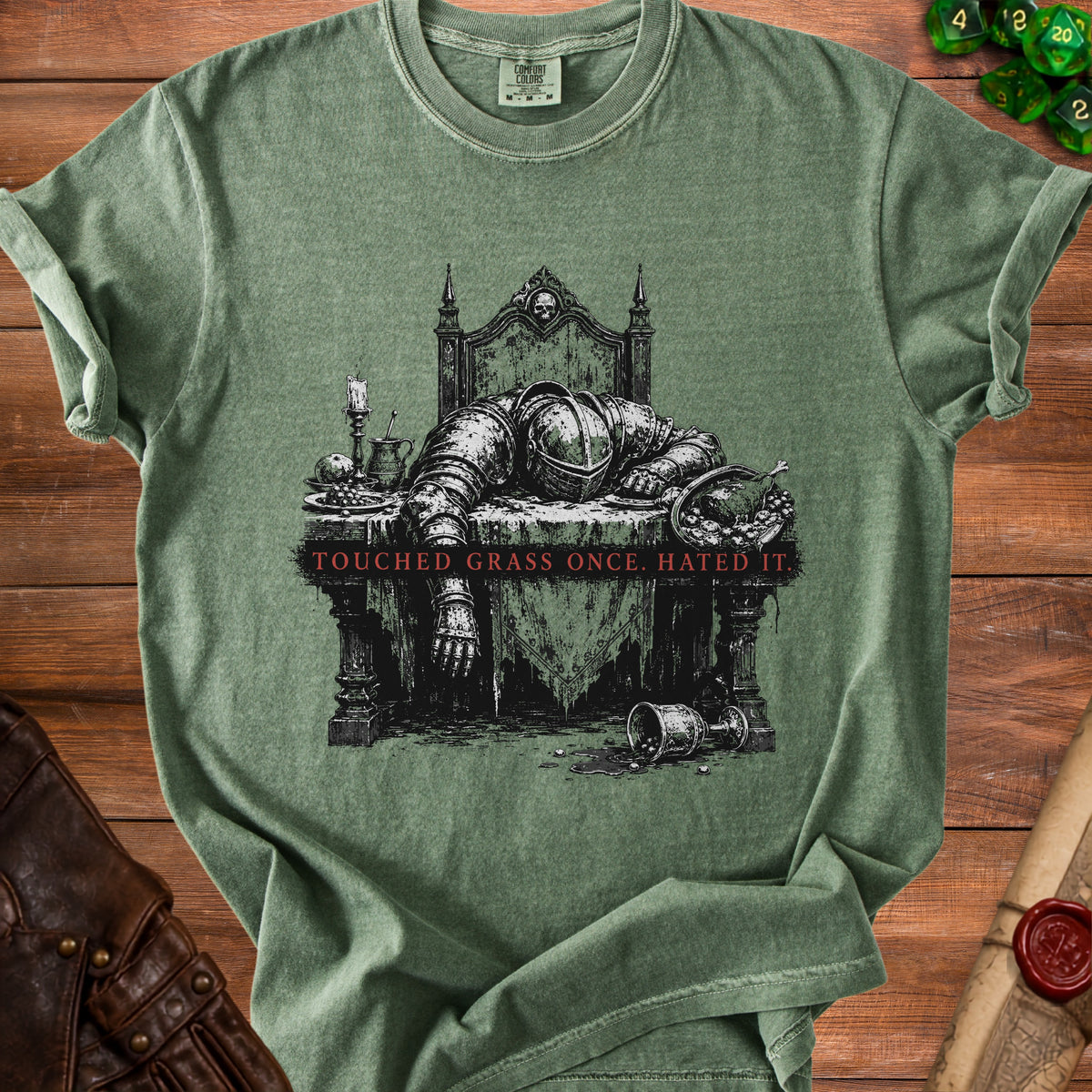 Green t-shirt with medieval knight slumped over a table and text "Touched Grass Once. Hated It."