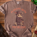 Brown t-shirt with plague doctor illustration and text "PLAGUED WITH PROBLEMS".