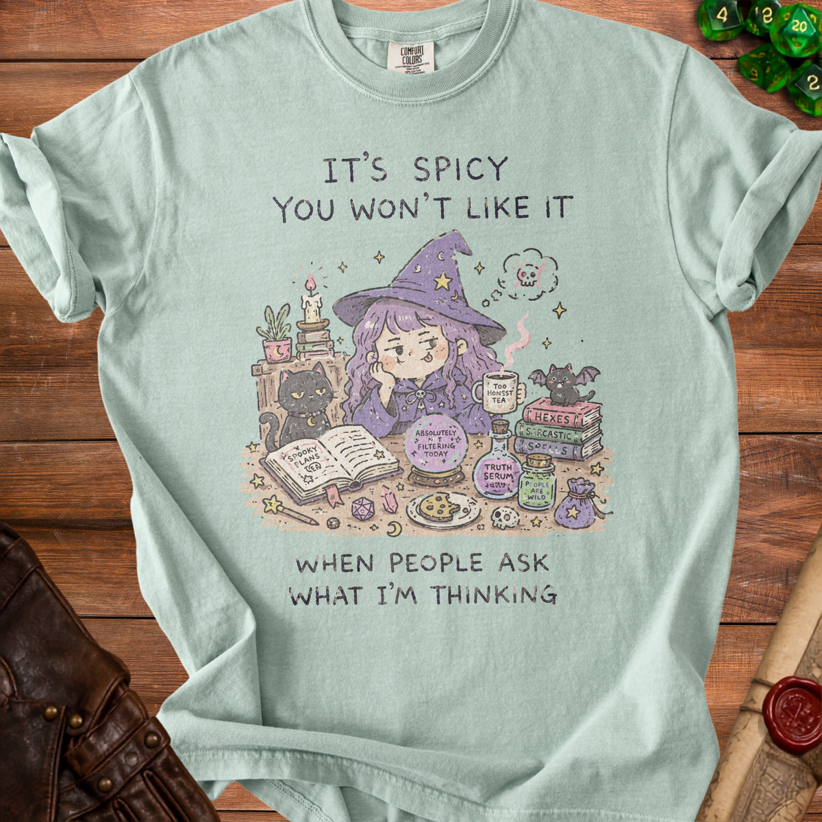 Light green t-shirt with "It's spicy you won't like it" and witch illustration.