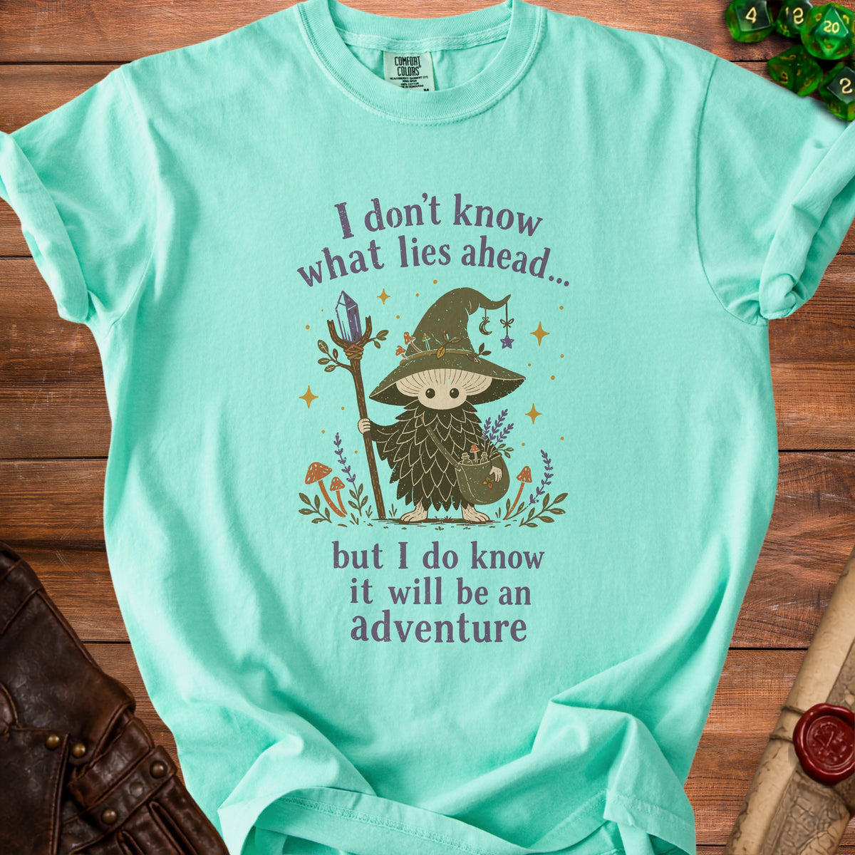 Aquamarine t-shirt with a mushroom wizard and text about adventure.