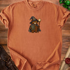 Orange t-shirt with cartoon wizard bear holding a book titled "Main Character Energy (Later)".