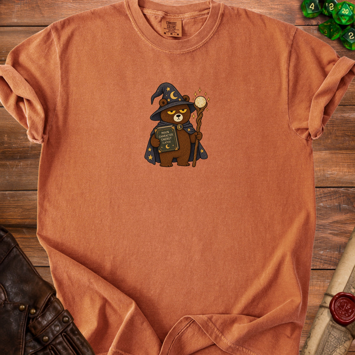 Orange t-shirt with cartoon wizard bear holding a book titled "Main Character Energy (Later)".