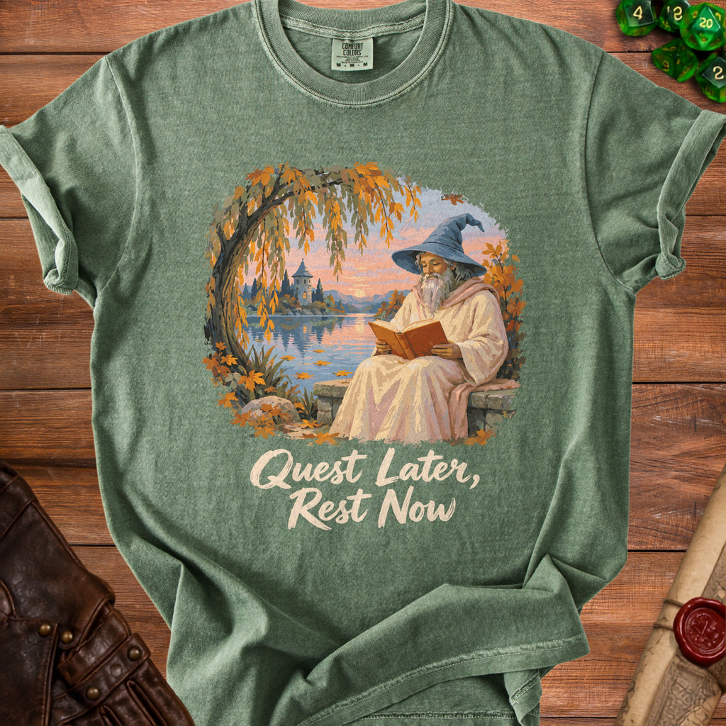Green t-shirt with wizard reading by water, castle, autumn leaves, and text.