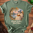 Green t-shirt with wizard reading by water, castle, autumn leaves, and text.