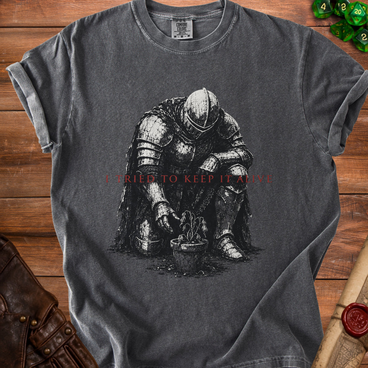 Dark gray t-shirt with knight tending a wilted plant, text "I TRIED TO KEEP IT ALIVE".