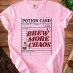 Pink t-shirt with "Potion Card: Brew More Chaos" design and dice.
