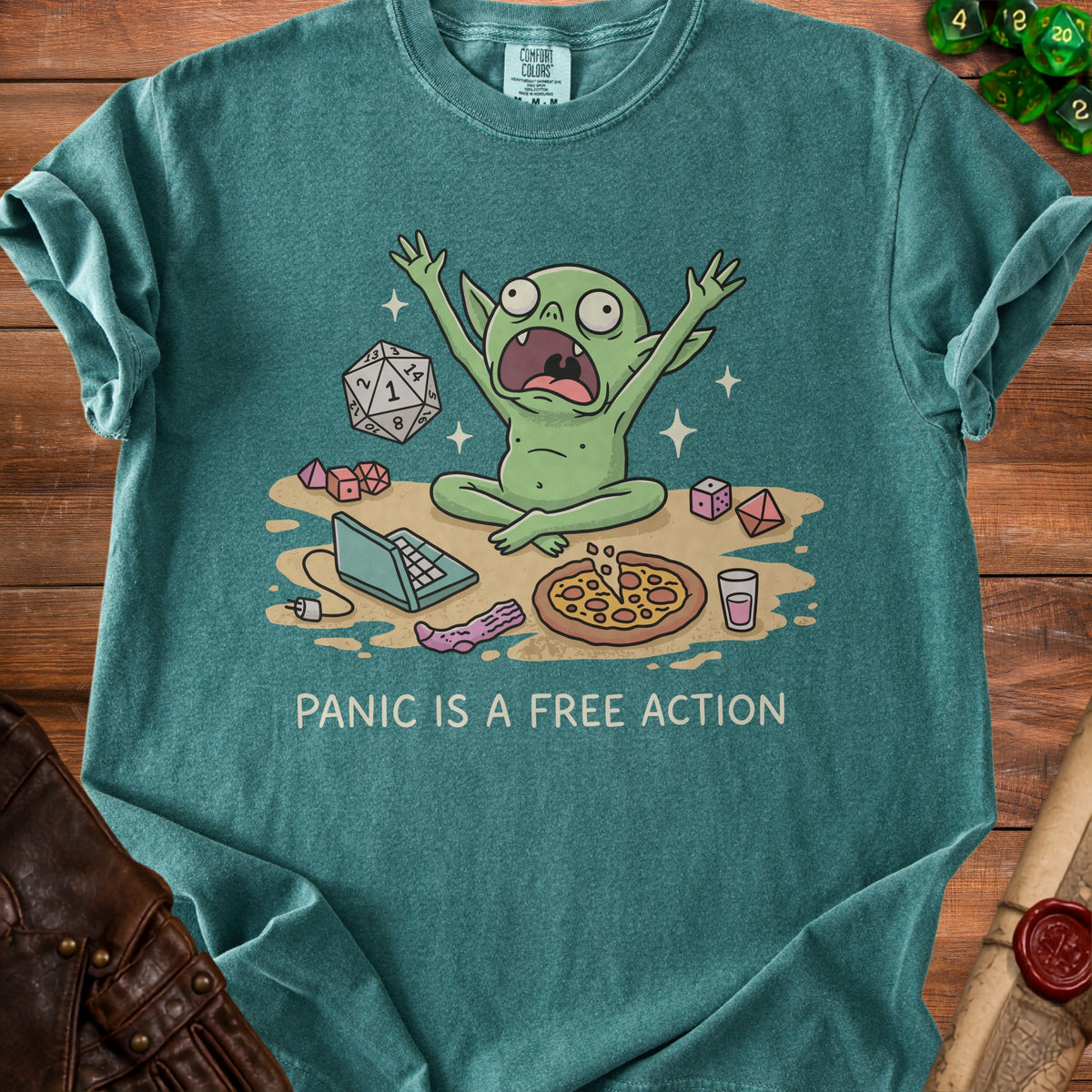 Green t-shirt with cartoon goblin, dice, pizza, laptop, and text "PANIC IS A FREE ACTION".