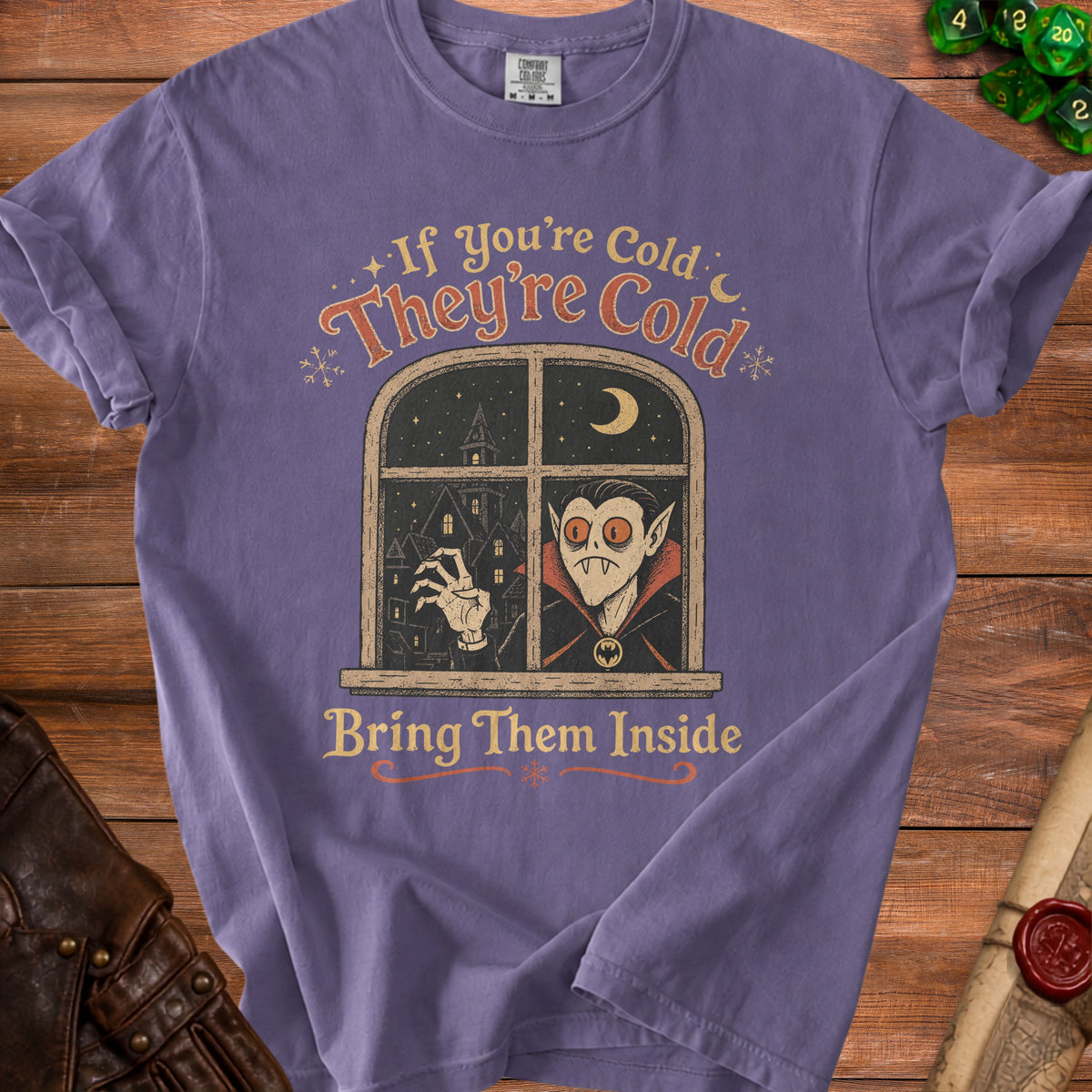 Purple t-shirt with a vampire in a window and text "If You're Cold They're Cold Bring Them Inside".