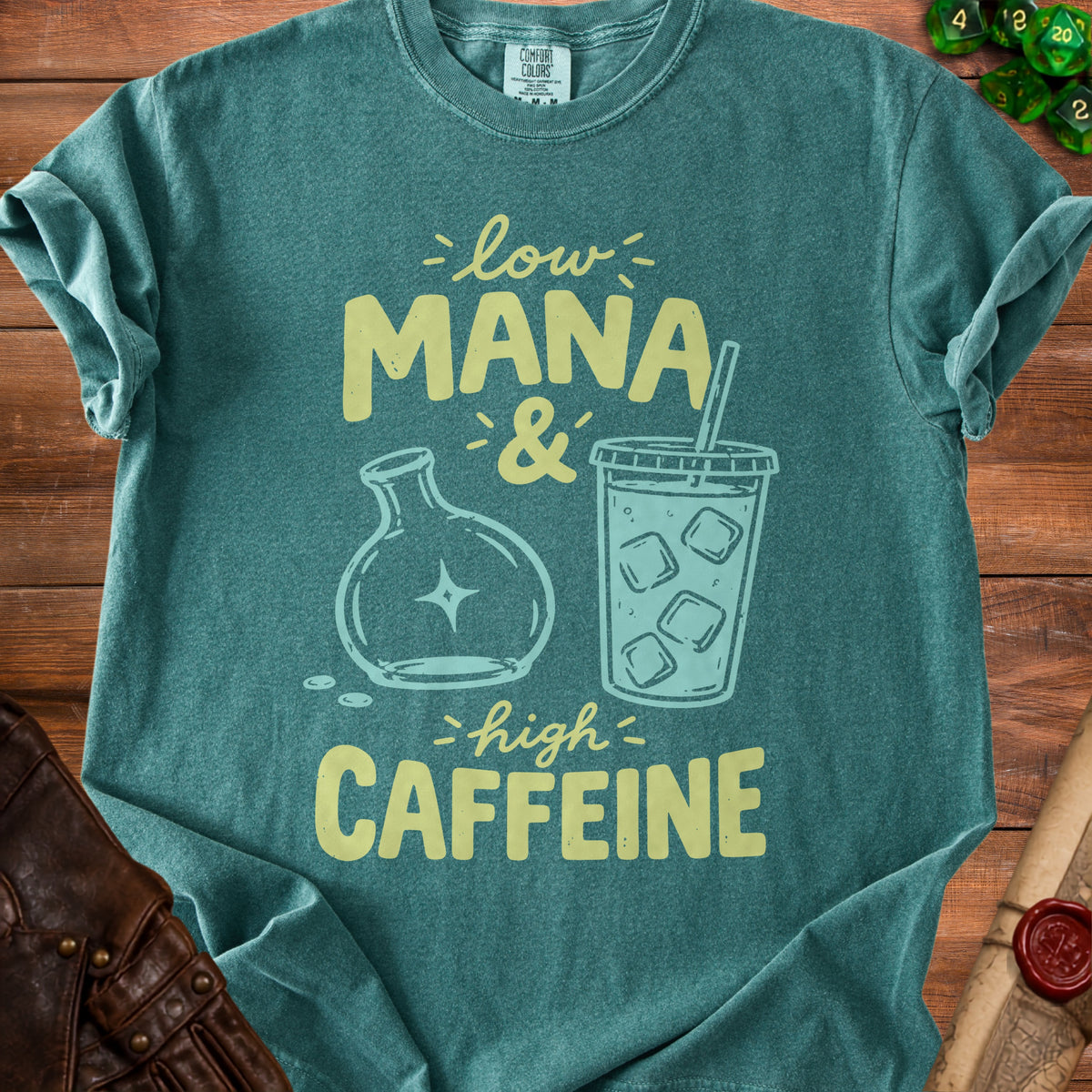 Teal t-shirt with "Low Mana & High Caffeine" graphic featuring a flask and iced coffee.