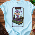 Light blue t-shirt with "WARNING: MAY CAST SARCASM AT WILL" and witchy graphics.