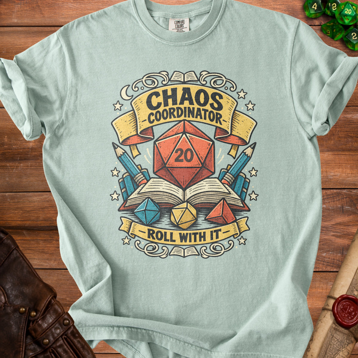 Light blue t-shirt with "Chaos Coordinator Roll With It" and dice graphics.