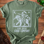 Green t-shirt with white graphic of knight on dog, moon, and stars, text "BAD IDEAS GOOD COMPANY".