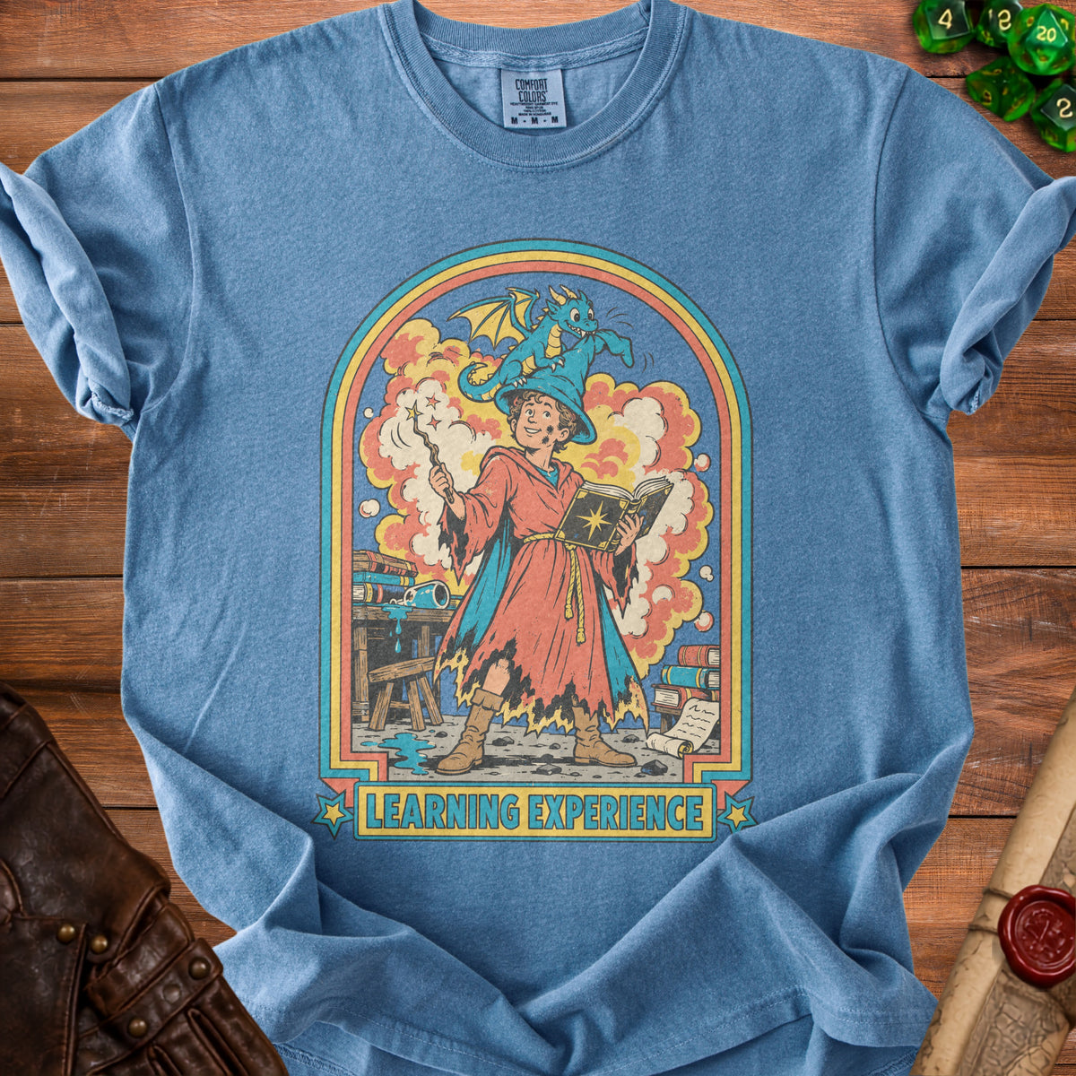 Blue t-shirt with a wizard, dragon, and books graphic reading "LEARNING EXPERIENCE."