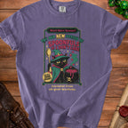Purple t-shirt graphic with a black cat holding a spoon, wearing a witch hat, and a cauldron. Text says "Need More Spoons? Try Our New Potion of Spoonfuls of I Don't Care."