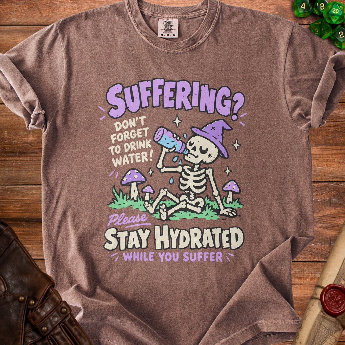 Brown t-shirt with skeleton graphic and text "Suffering? Don't forget to drink water! Please Stay Hydrated While You Suffer."
