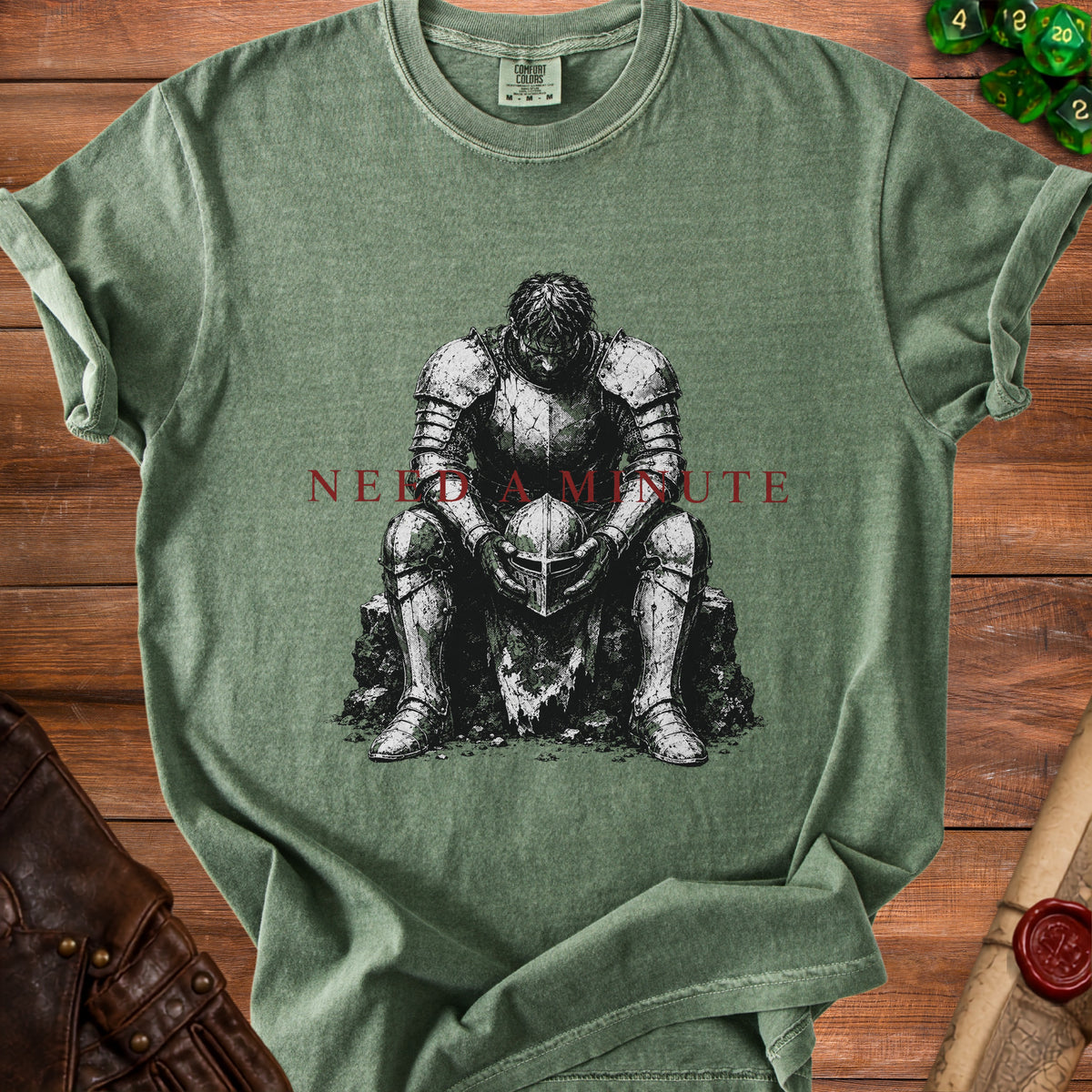 Green t-shirt with a knight holding a helmet and the text "NEED A MINUTE".
