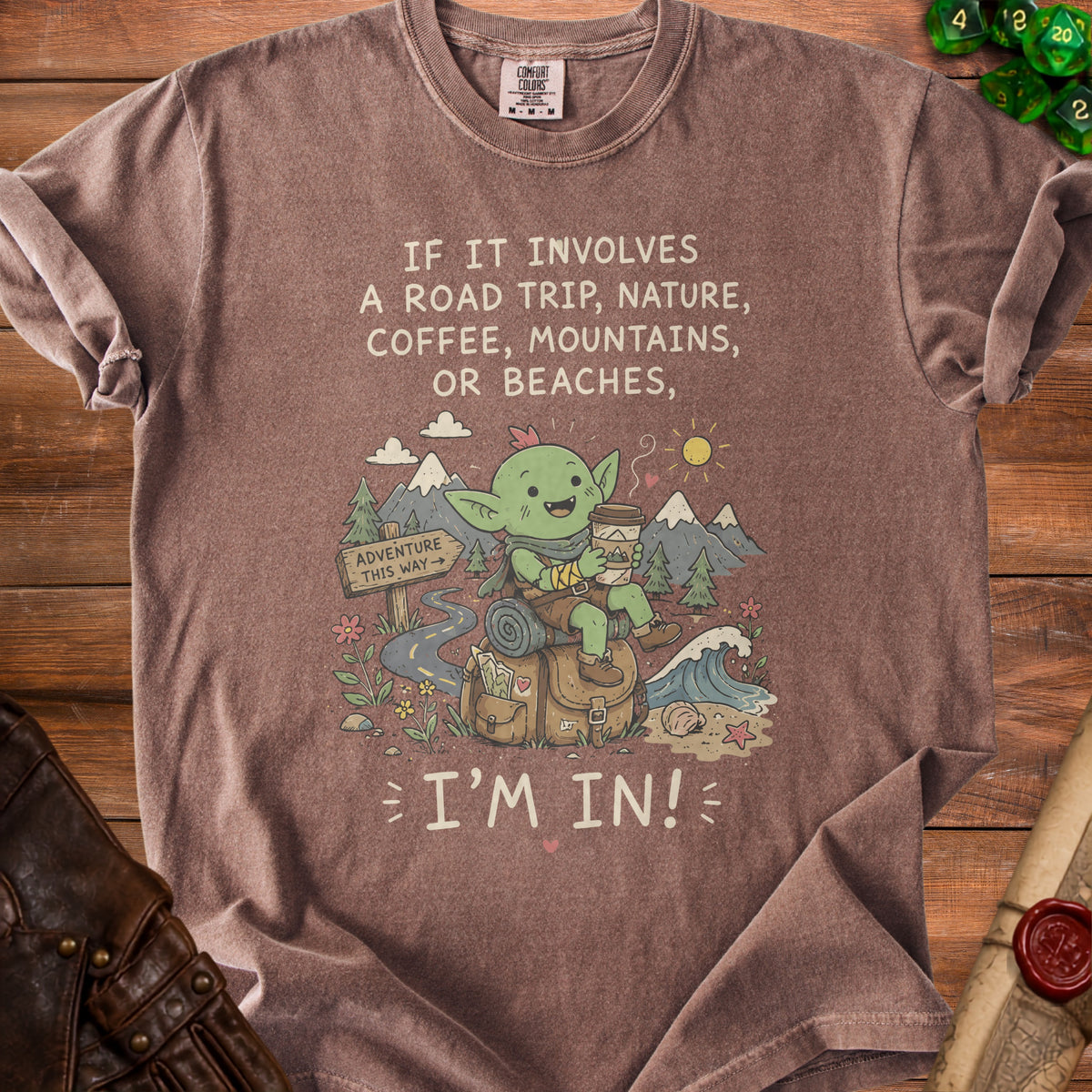 Brown t-shirt with "If it involves a road trip, nature, coffee, mountains, or beaches, I'm in!" text.