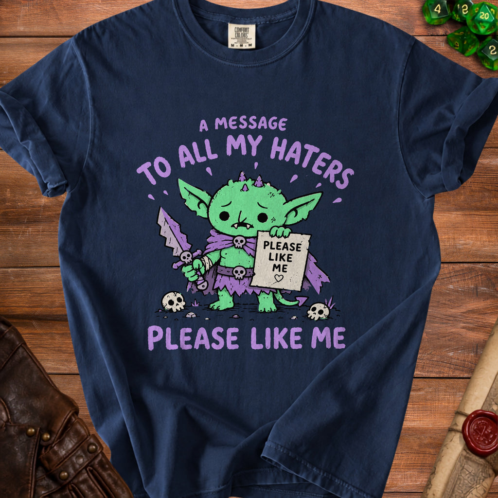 Navy t-shirt with a sad green goblin holding a sign and sword.