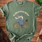 Wizard riding bicycle with cat, text "My Familiar Called Shotgun".