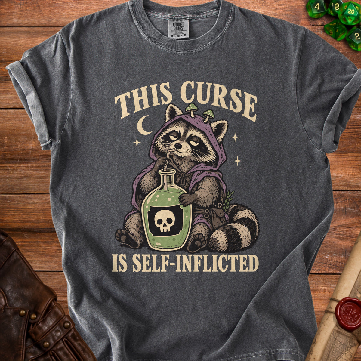 Dark gray t-shirt with raccoon graphic and text "THIS CURSE IS SELF-INFLICTED".