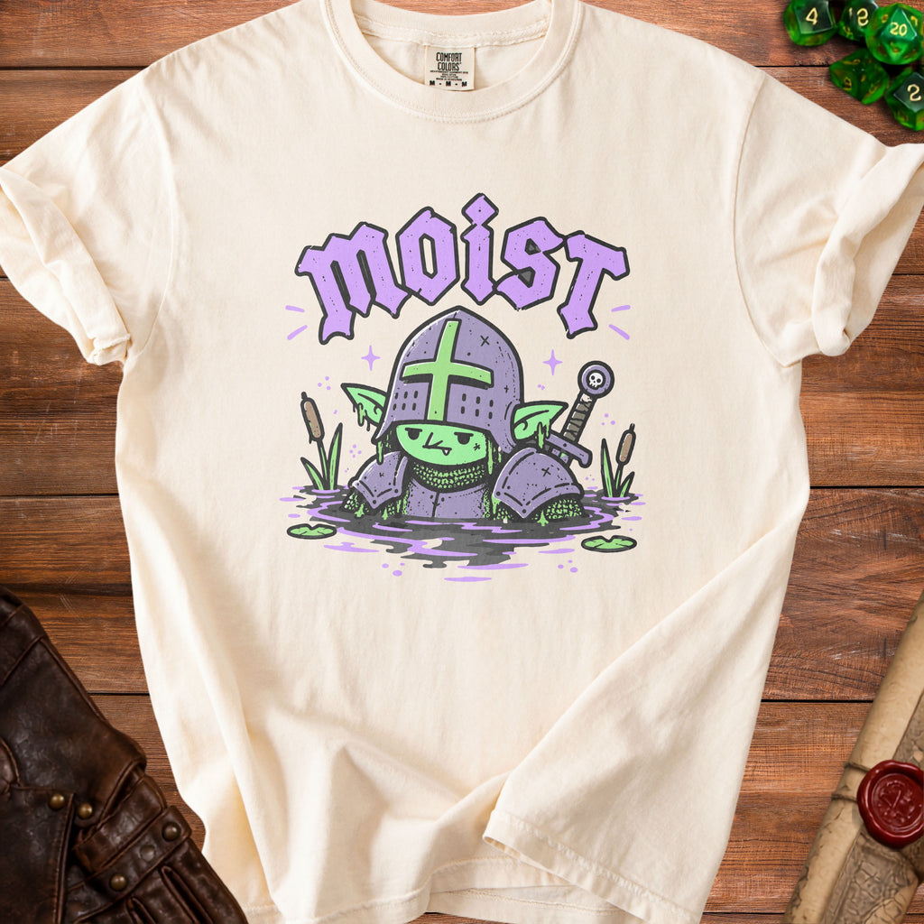 Cream t-shirt with a cartoon goblin knight in purple armor saying "moist".