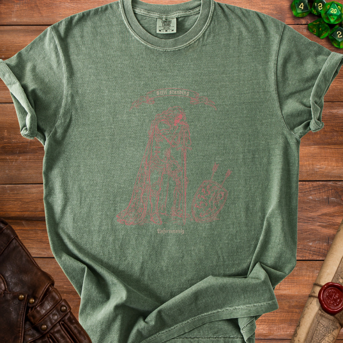 Green t-shirt with a red outline graphic of a knight holding a sword and shield, with text.