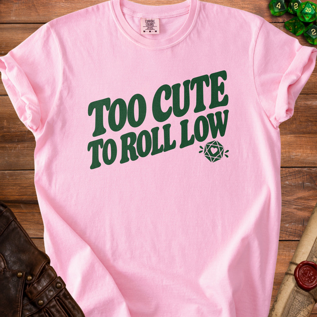 Pink t-shirt with green text "TOO CUTE TO ROLL LOW" and dice graphic.