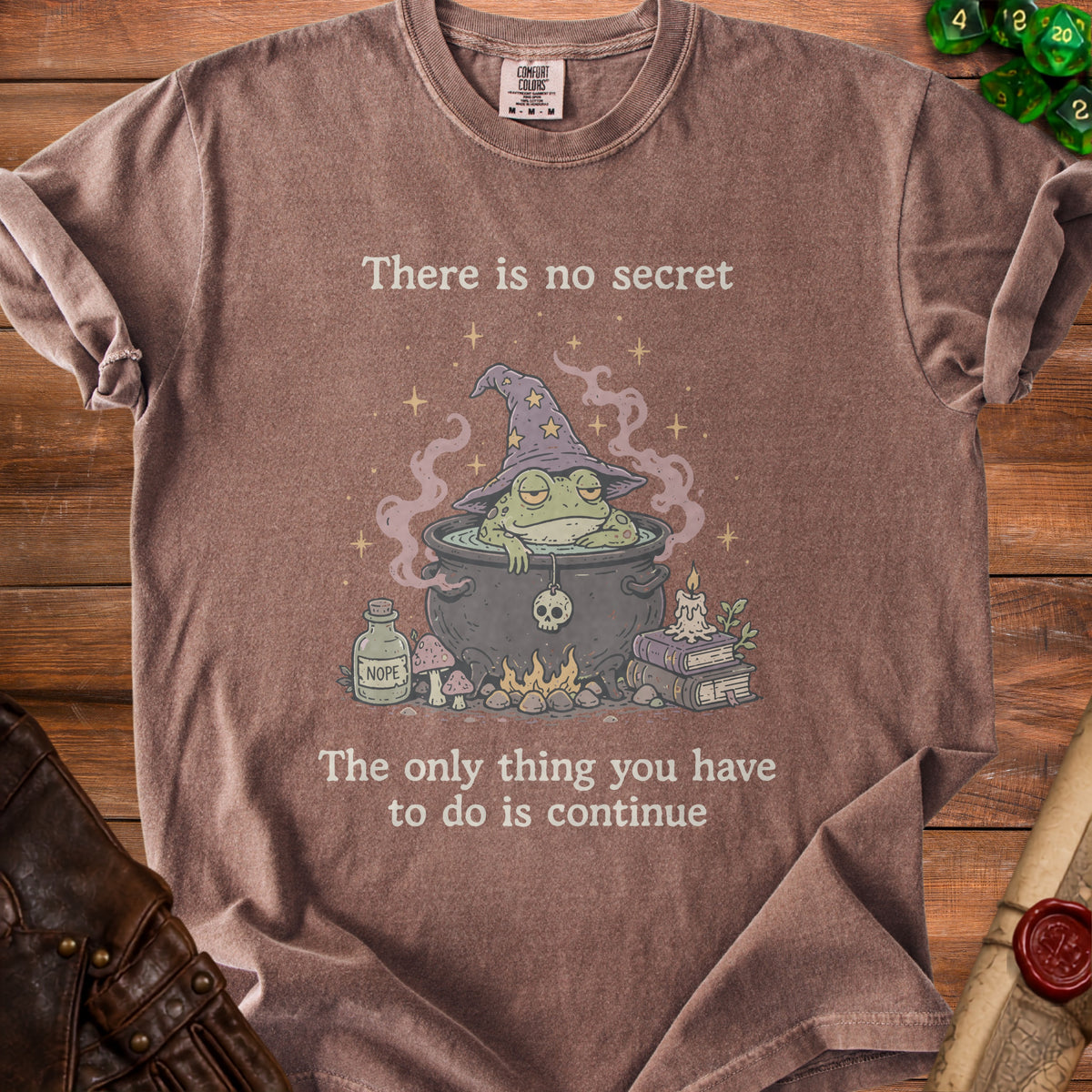 Brown t-shirt with a frog wizard in a cauldron and text.