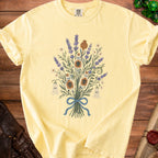 Yellow t-shirt with lavender, ghosts, and skull potion bottle graphic.