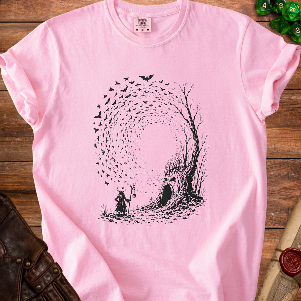 Pink t-shirt with a black graphic of a wizard, a hollow tree with a face, and swirling bats.