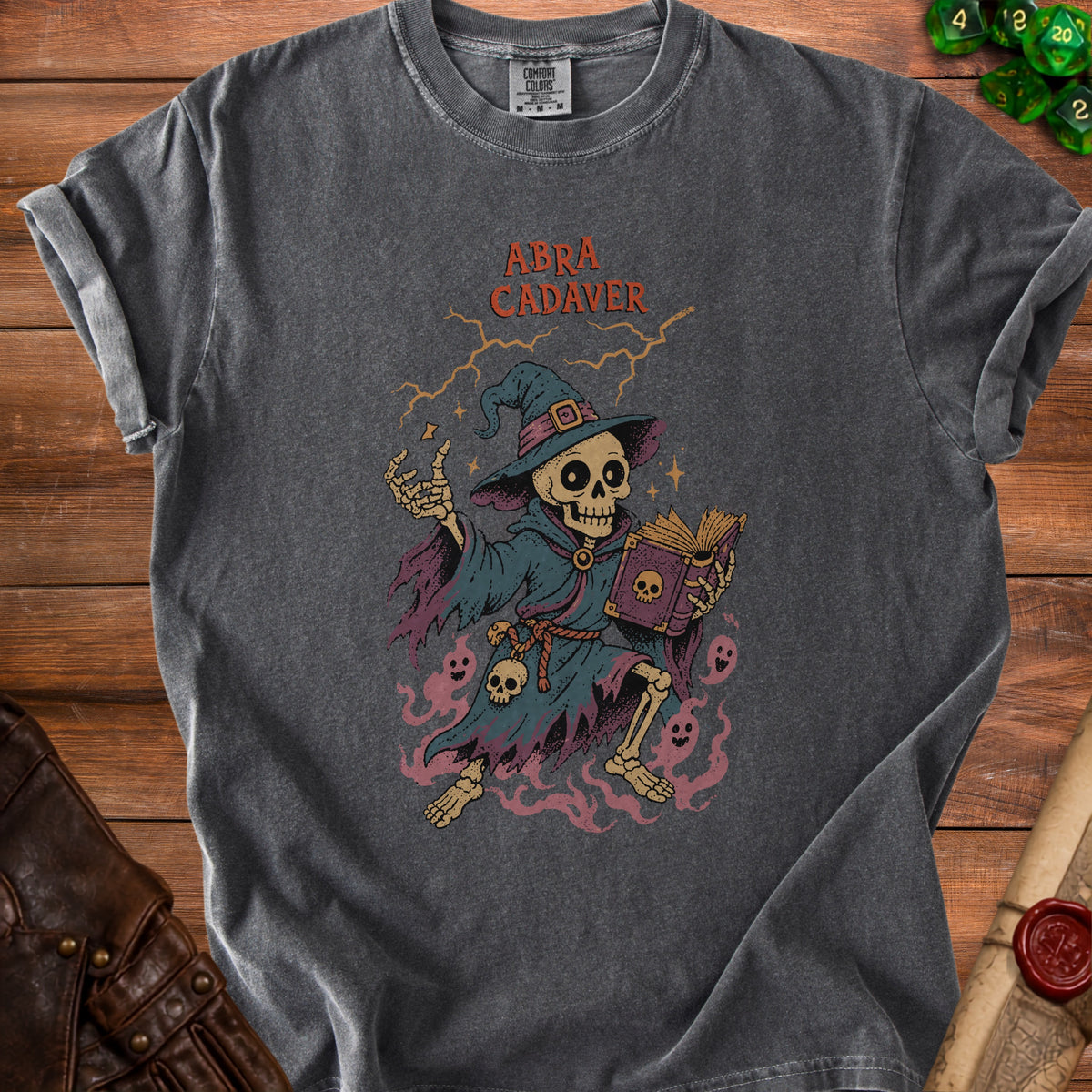 A skeleton wizard with text "ABRA CADAVER" on a gray t-shirt.