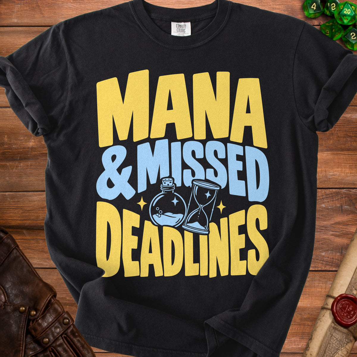 Black t-shirt with yellow and blue text reading "MANA & MISSED DEADLINES"