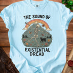 Light blue t-shirt with skeleton, black cat, butterflies, mountains, and text "The Sound of Existential Dread".