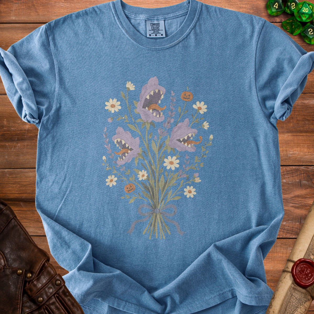 Blue t-shirt with a bouquet of predatory flowers, daisies, and pumpkins.