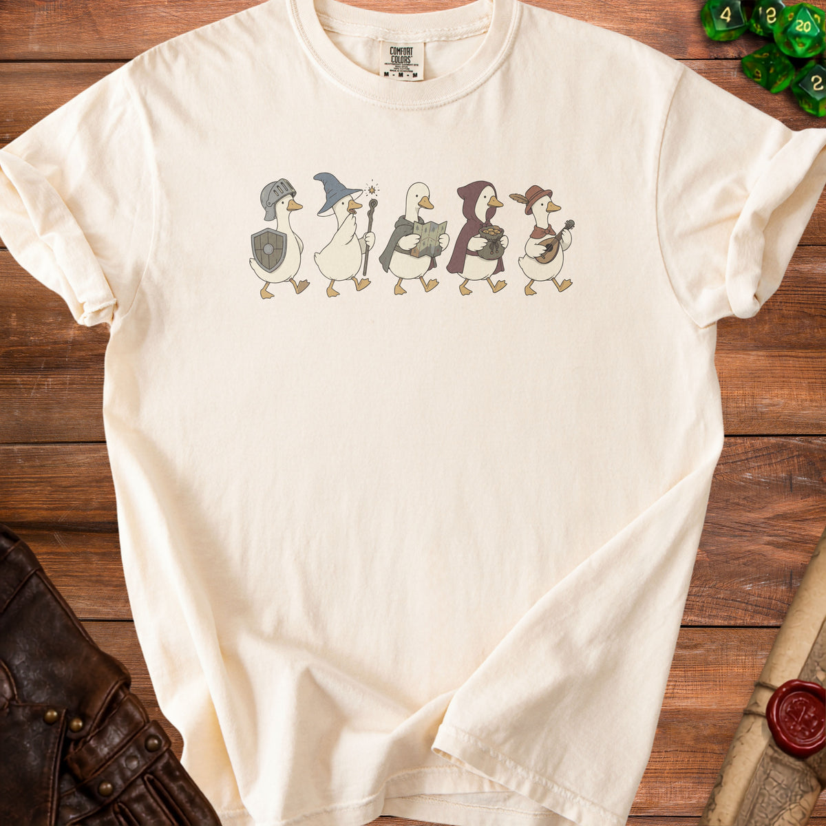 Cream t-shirt with five walking cartoon geese dressed as fantasy adventurers.