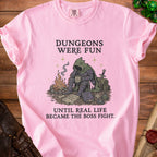 Pink t-shirt with graphic: "Dungeons were fun until real life became the boss fight."
