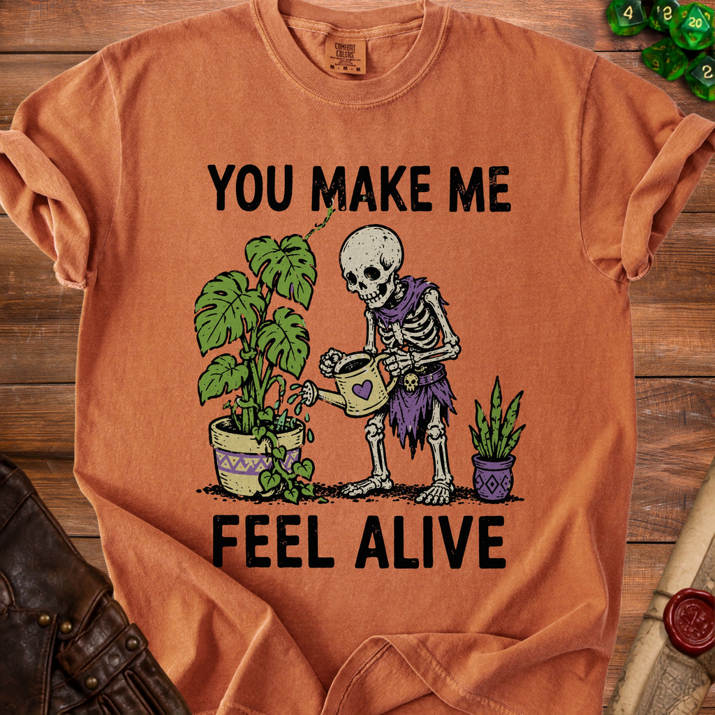 Skeleton watering plants with text "YOU MAKE ME FEEL ALIVE".