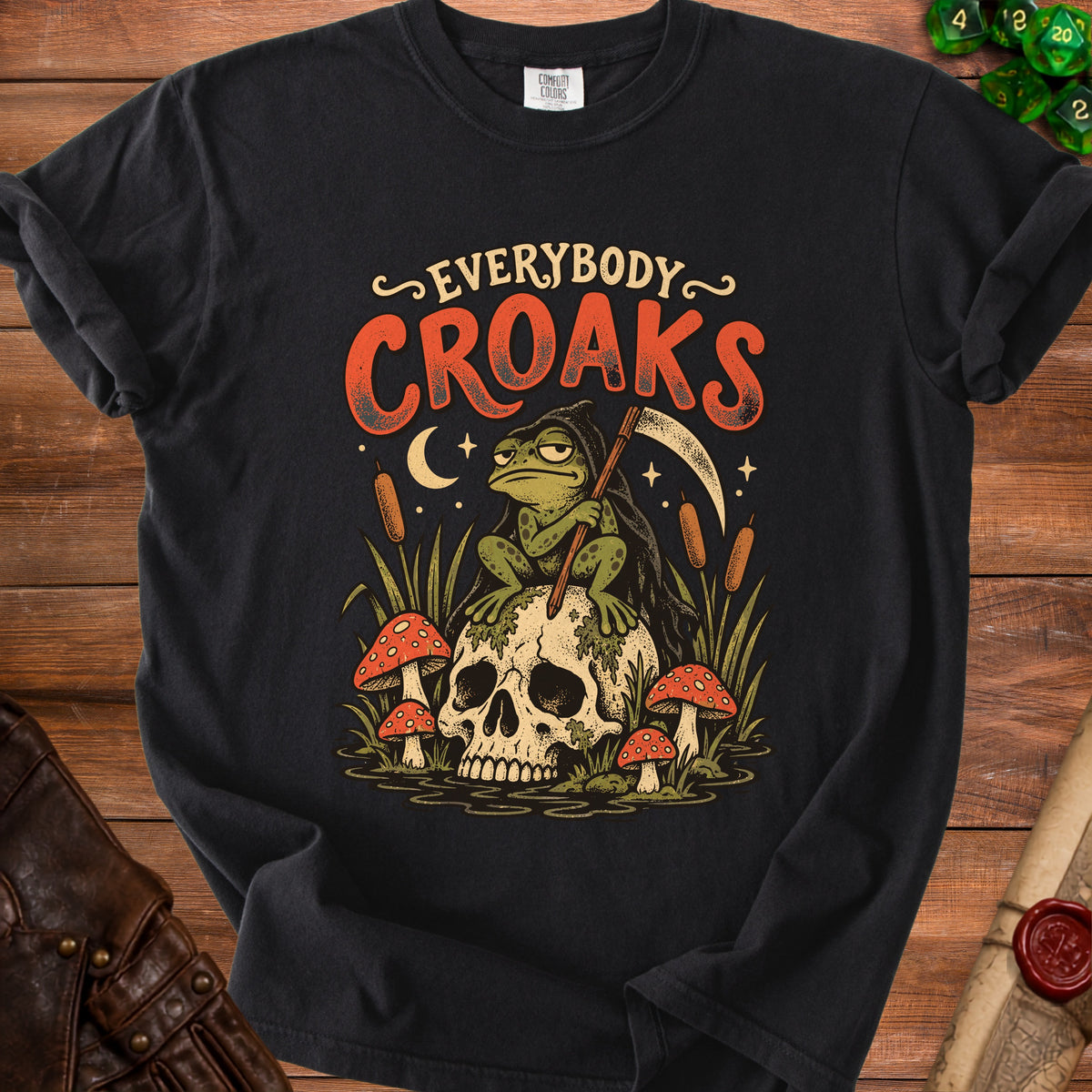 Black t-shirt with a grim reaper frog sitting on a skull with mushrooms.