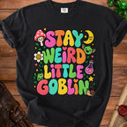Black t-shirt with "STAY WEIRD LITTLE GOBLIN" in colorful, bubbly letters and whimsical graphics.