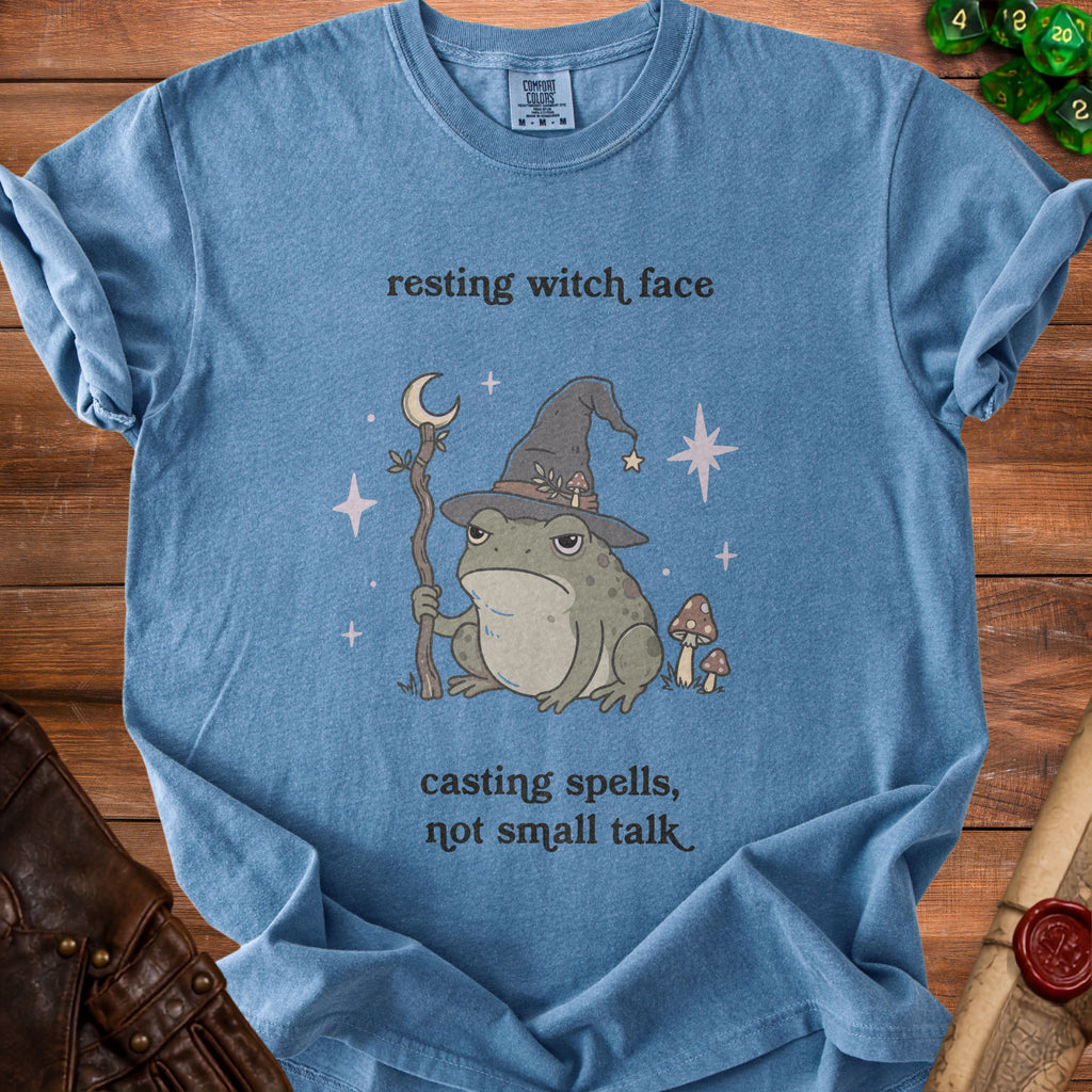 Blue Comfort Colors t-shirt with a frog wearing a witch hat and the text "resting witch face, casting spells, not small talk".