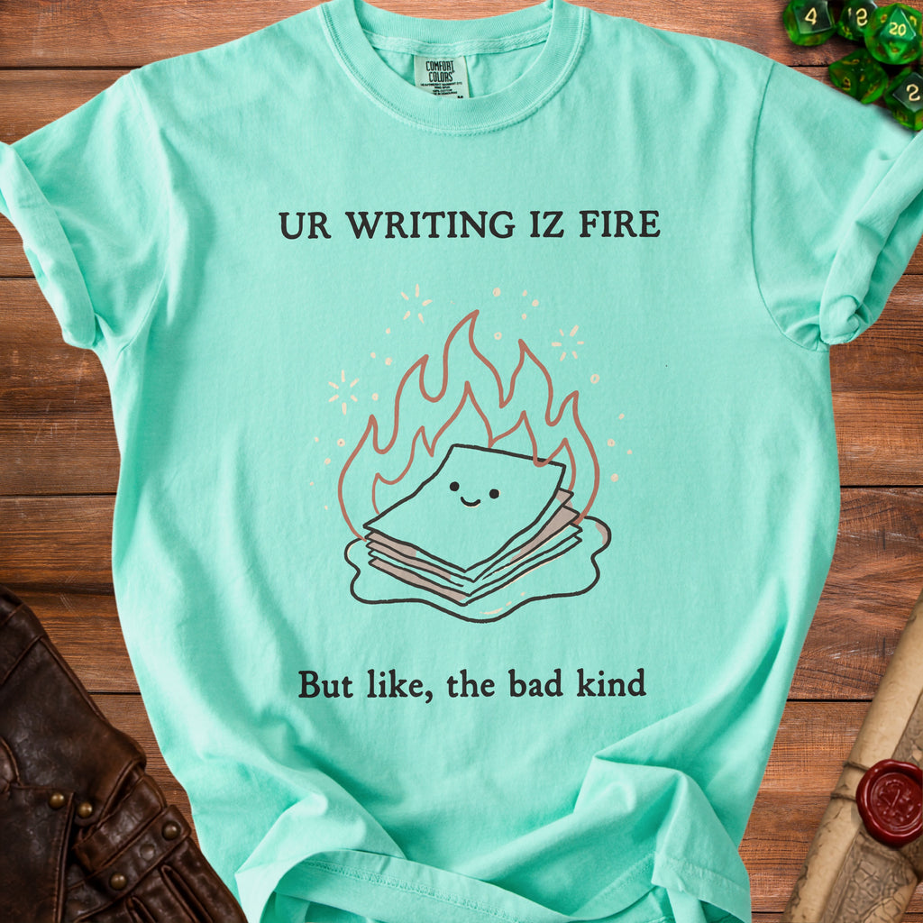 Aqua t-shirt with "UR WRITING IZ FIRE But like, the bad kind" and a cartoon pile of papers on fire.