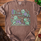 Cats in armor explore a treasure chest on a shelf with books titled "Dungeons," "Monsters," "Curses," and "Bestiary."